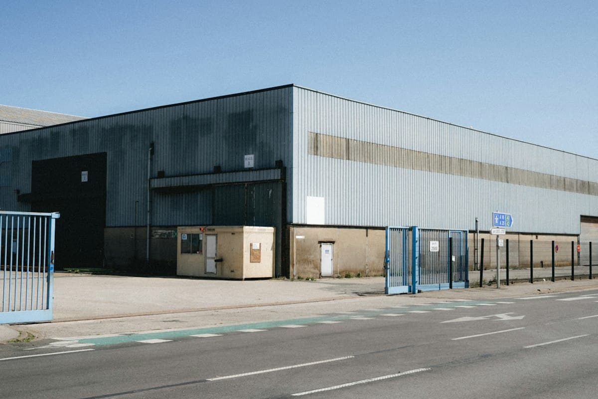 Exterior de nave industrial con fachada metálica y acceso vehicular